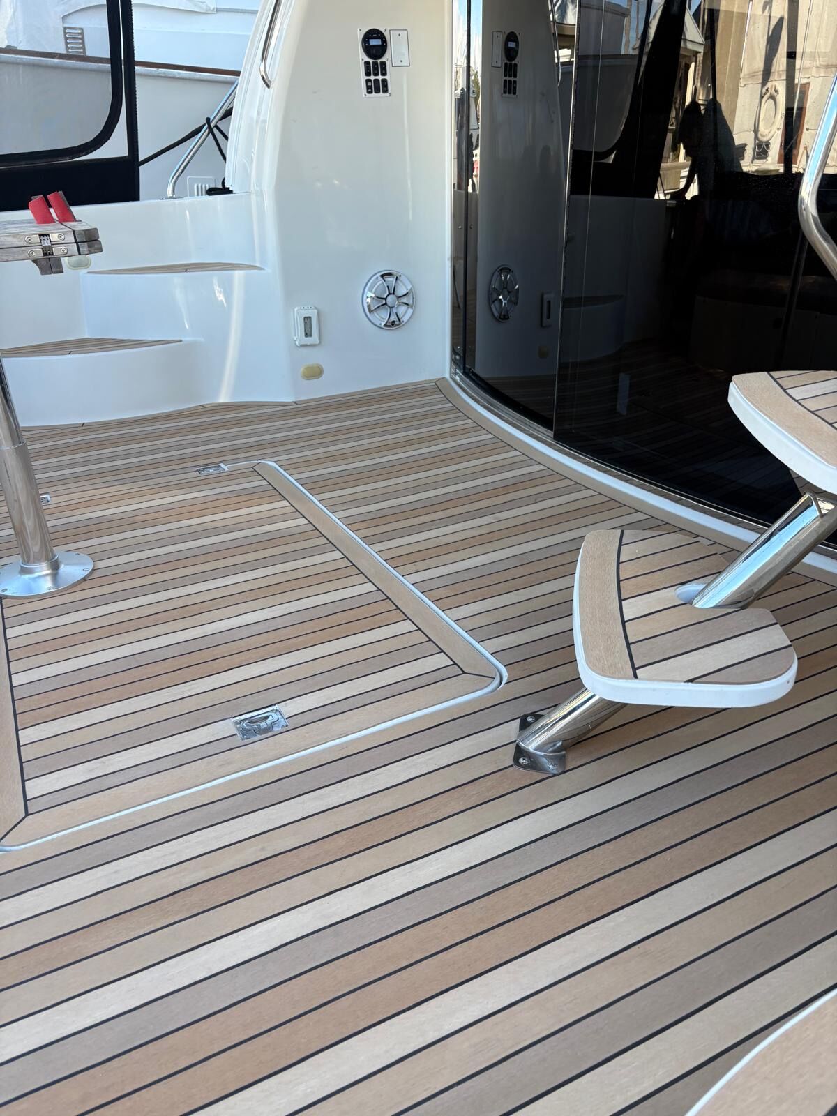 Synthetic teak cockpit sole with a flush deck hatch outlined by a continuous margin plank