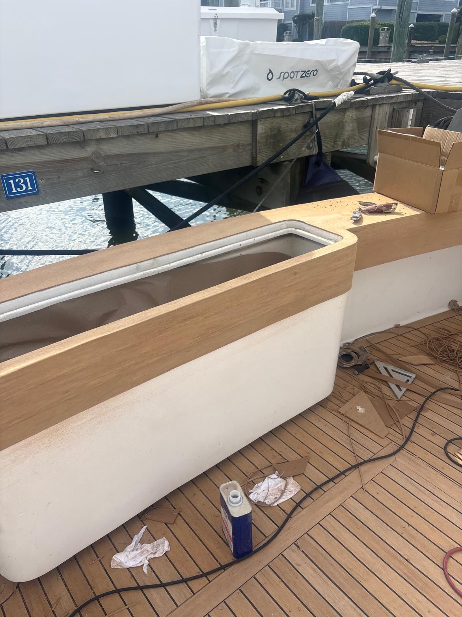 Freshly fitted synthetic teak coaming top and covering board with fabrication offcuts on the deck
