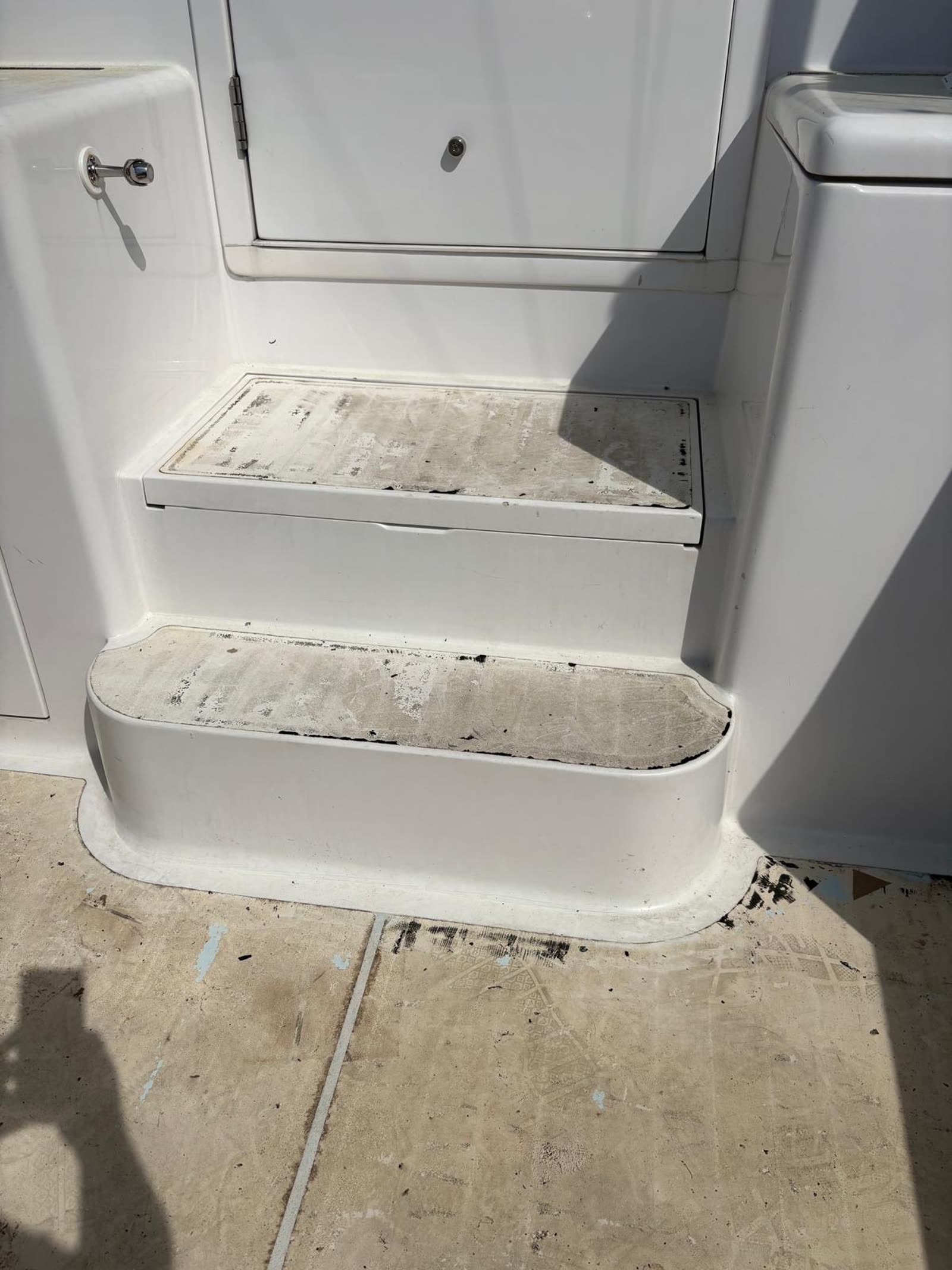 Sportfish cabin steps with old deck material removed leaving adhesive residue on the fibreglass treads