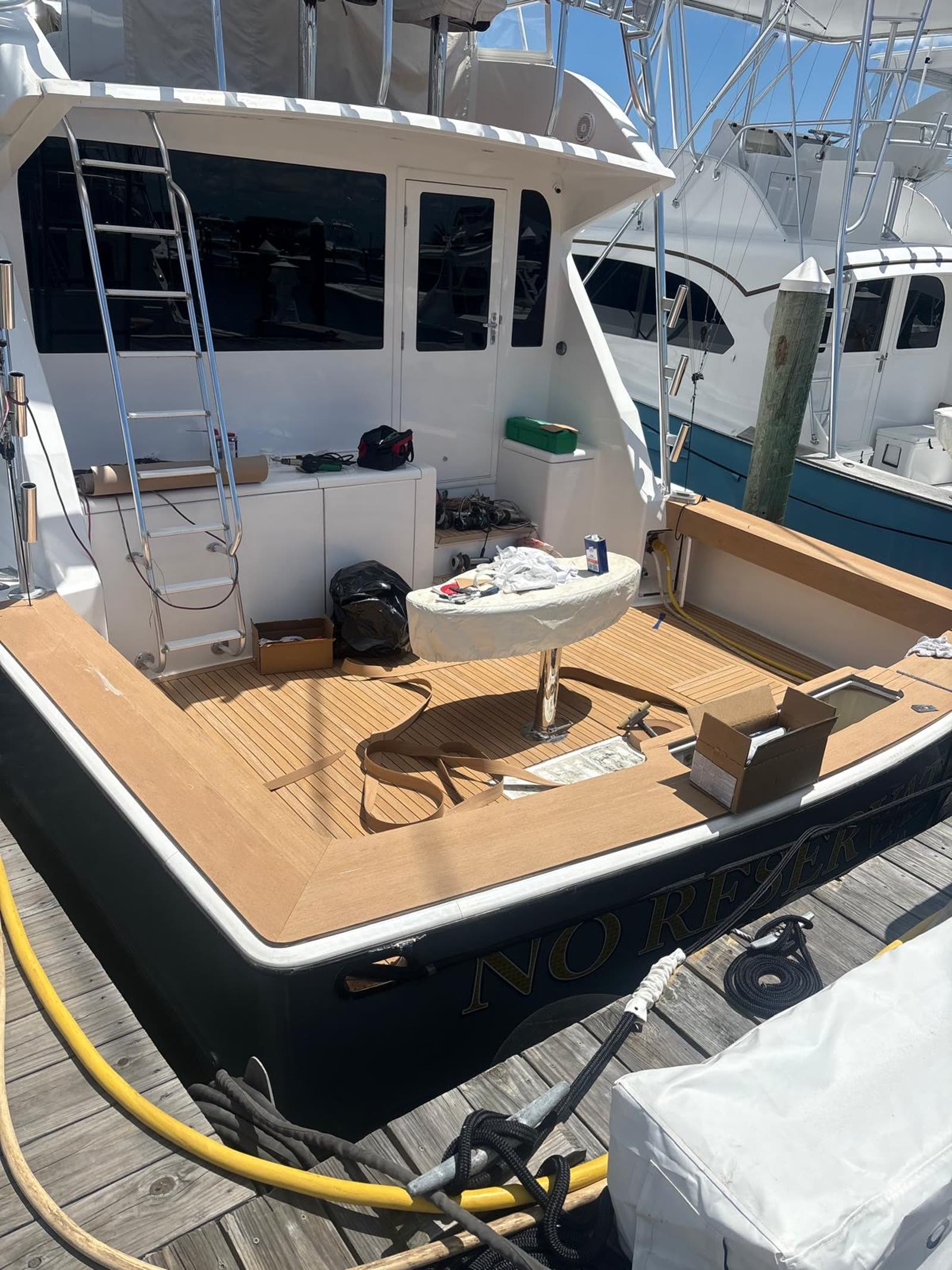 Sportfish cockpit dockside with new synthetic teak deck laid and installer tools still on the boat