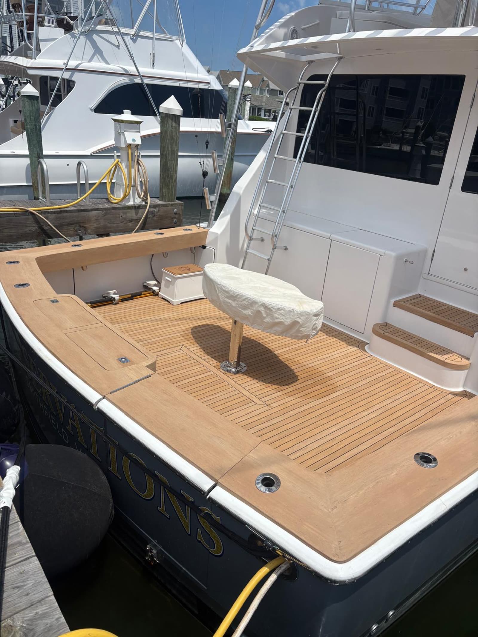 Sportfish cockpit sole in synthetic teak laid around the fighting chair base with flush rod holders