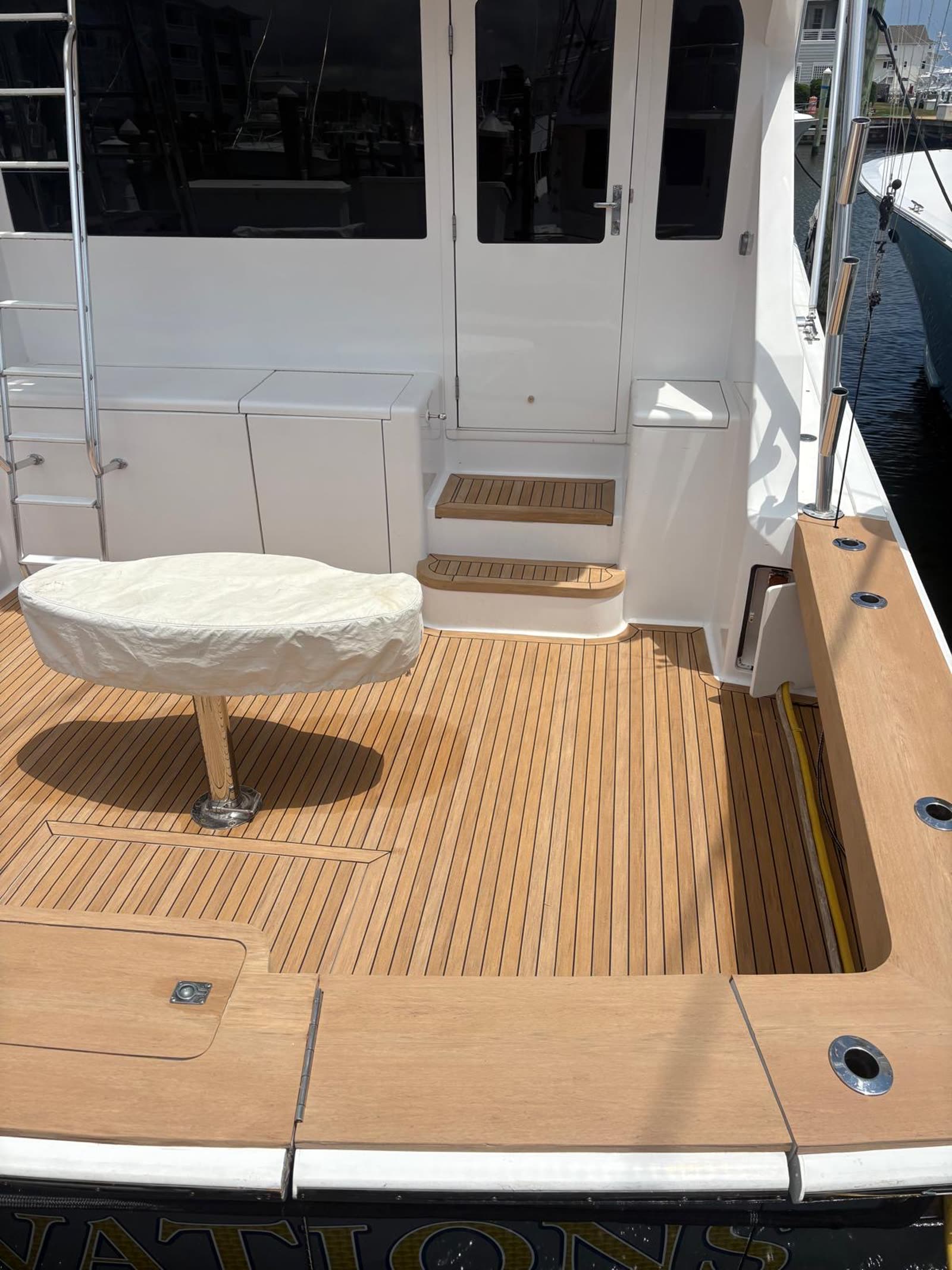 Close view of synthetic teak cockpit steps, hatch cut-outs and the margin running to the coaming